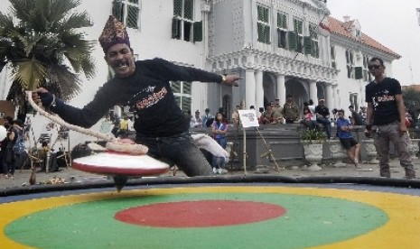 Seorang pemain gasing yang tergabung dalam Komunitas Gasing Indonesia menunjukkan permainannya di Kawasan Kota Tua, Jakarta.