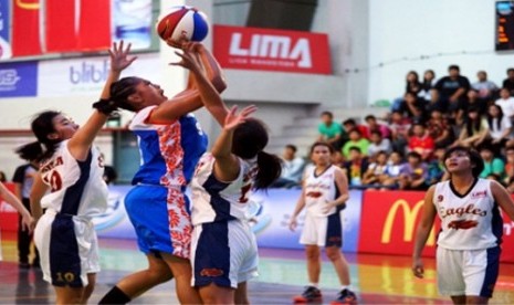 Seorang pemain putri UEU melepaskan tembakan di tengah penjagaan para pemain UPH dalam pertandingan  LIMA Basketball Air Mineral Prim-A Greater Jakarta Conference Season 3, Ahad (23/11).