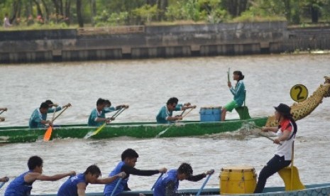 Seorang pemandu terus memberi semangat anggota timnya untuk memukul bedug pada lomba perahu naga dalam Festival Erau Adat Pelas Benua Etam 2012 di Sungai Mahakam, Kota Tenggarong, Kabupaten Kutai Kartanegara, Kalimantan Timur, Rabu (4/7).