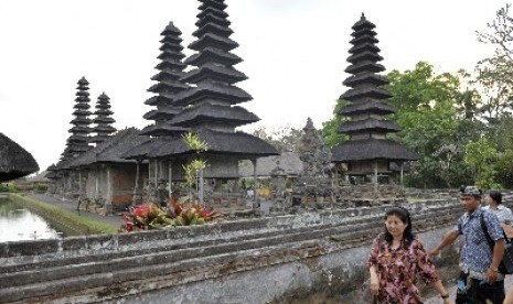 Seorang pemandu wisata mengarahkan wisatawan saat berkunjung ke Pura Taman Ayun, Badung, Bali