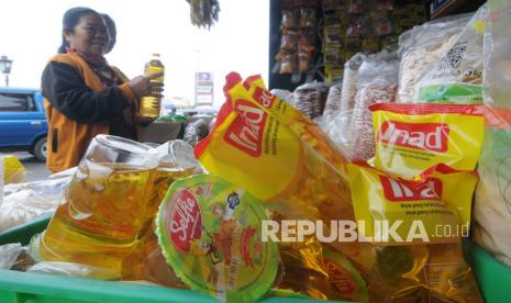 Seorang pembeli memilih minyak goreng premium yang dijual di pasar. 