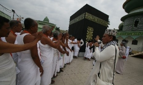   Seorang pembimbing memberi arahan kepada sejumlah calon jamaah haji yang berlatih melakukan tawaf saat mengikuti manasik haji di Medan, Sumut