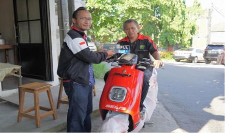 Pemilik usaha warung, Nureman (kanan), orang pertama mendapatkan motor listrik Selis dengan menggunakan bantuan pembelian motor listrik dari Pemerintah.