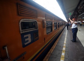 Seorang pemimpin peron memberangkatkan rangkaian kereta api di Stasiun Pasar Senen, Jakarta, Senin (23/1).  (Republika/Wihdan Hidayat)