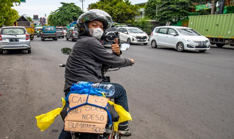 Seorang pemudik sepeda motor dari Pulau Sumatera tujuan Surakarta yang mengikuti rombongan berpose saat menunggu rekannya yang tertinggal di jalur Pantura, Ngaliyan Semarang, Jawa Tengah, Rabu (27/4/2022). Mereka mengaku memilih mudik secara kolektif atau rombongan dalam upaya saling menjaga dalam perjalanan sekaligus memupuk tali persaudaraan antarpemudik. Pemudik Sepeda Motor Mulai Ramaikan Jalur Selatan Jateng