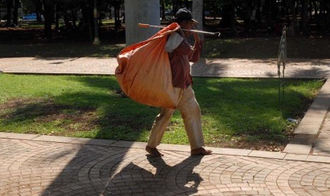   Seorang pemulung mencari sampah di kawasan Monas, Jakarta Pusat, Jumat (21/12). (Republika/Agung Fatma Putra)