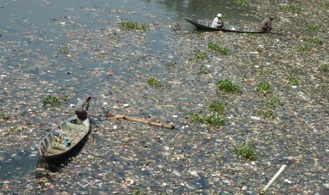 Seorang pemulung menggunakan sampan mencari rongsokan berharga di Sungai Citarum, daerah Batujajar, Kabupaten Bandung. (Republika/Edi Yusuf)