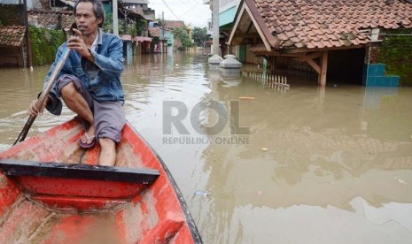    Seorang penduduk menyusuri perkampungan yang sudah terendam banjir di Cieunteung, Kecamatan Baleendah, Kabupaten Bandung, Ahad (15/12).  (Republika/Edi Yusuf)