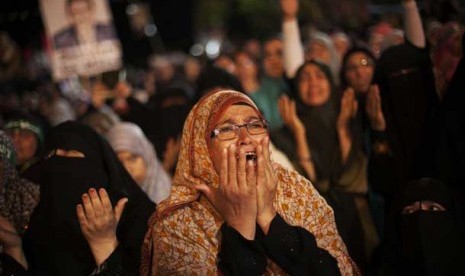  Seorang pendukung Presiden Mursi menangis saat protes menolak kudeta militer di Nasr City, Kairo, Senin (29/7).