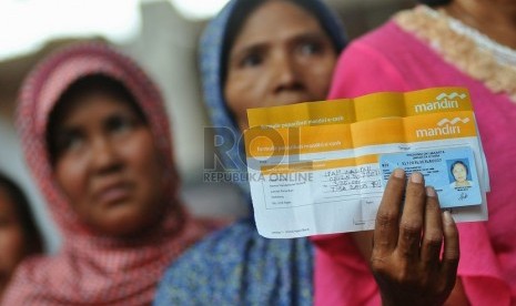  Seorang penerima bantuan sosial melakukan penarikan uang melalui agen Layanan Keuangan Digital (LKD) saat uji coba penyaluran dana bantuan Program Keluarga Harapan (PKH) melalui uang elektronik di Jakarta, Rabu (8/10).   (Republika/Prayogi)