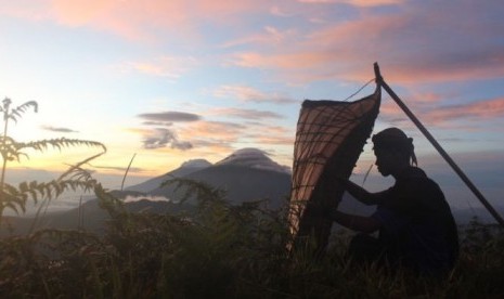  Seorang pengangon bebek memainkan bundengan di Wonosobo, Jawa Tengah.