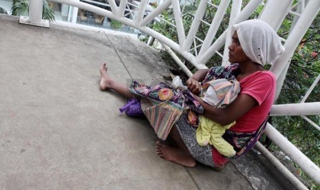  Seorang pengemis beraksi meminta sumbangan dari para pejalan kaki di Jembatan Penyeberangan Orang (JPO) Sarinah, Jakarta Pusat, Rabu (12/3). (Republika/Yasin Habibi)