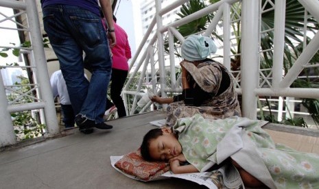  Seorang pengemis beraksi meminta sumbangan dari para pejalan kaki di Jembatan Penyeberangan Orang (JPO) Sarinah, Jakarta Pusat, Rabu (12/3). (Republika/Yasin Habibi)