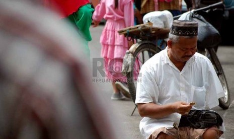 Seorang pengemis meminta-minta kepada jamaah setelah shalat jumat yang dilaksanakan di Masjid Istiqlal, Jakarta Pusat, Jumat (18/7). (Republika/Raisan Al Farisi)