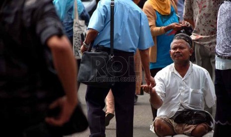 Seorang pengemis meminta-minta kepada jamaah setelah shalat jumat yang dilaksanakan di Masjid Istiqlal, Jakarta Pusat, Jumat (18/7). (Republika/Raisan Al Farisi)