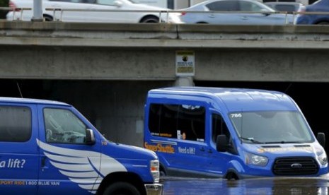 Seorang pengemudi berusaha memindahkan mobilnya melewati jalanan yang digenangi banjir akibat badai el-Nino di San Diego, California (6/1).