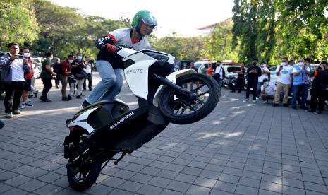 Seorang pengendara menampilkan atraksi dengan kendaraan listrik saat kegiatan PLN E-Mobility Day: Driving The Future di Denpasar, Bali, Ahad (24/7/2022). Grab Indonesia bersama PT Perusahaan Listrik Negara Persero (PLN) menambah jumlah Stasiun Penukaran Baterai Kendaraan Listrik Umum (SPBKLU) di enam provinsi di Jawa dan Bali.