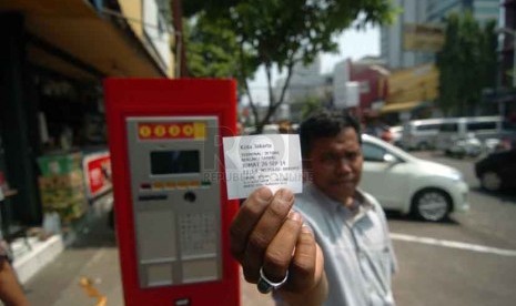 Seorang pengendara roda empat memasukan koin di parkir meter di Jalan Sabang, Jakarta Pusat, Jumat (26/9). (Republika/Raisan Al Farisi).