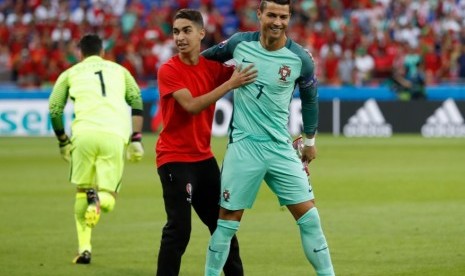 Seorang penggemar Cristiano Ronaldo menyusup ke lapangan untuk mengajak foto bersama sebelum laga Portugal kontra Wales.