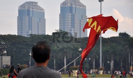  Seorang pengrajin layang-layang, Agus Pirano (50) mempersiapkan layangannya untuk diterbangkan di kawasan silang Monas, Jakarta, Ahad (9/6).  (Republika/Rakhmawaty La'lang)