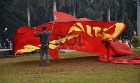  Seorang pengrajin layang-layang, Agus Pirano (50) mempersiapkan layangannya untuk diterbangkan di kawasan silang Monas, Jakarta, Ahad (9/6).  (Republika/Rakhmawaty La'lang)