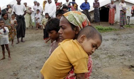 Seorang pengungsi etnis Rohingya membawa anaknya di kamp pengungsi Pha Du di Sittwe, Negara Bagian Rakhine, Myanmar, Rabu, (1/8).