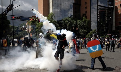 Seorang pengunjuk rasa melemparkan bom molotov saat berunjuk rasa di Kota Karakas, Venezuela, Kamis (22/6).