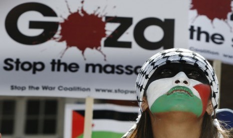   Seorang pengunjuk rasa mengecam agresi militer ke Gaza di depan Kedubes Israel di London, Sabtu (26/7). (REUTERS/Luke MacGregor) 