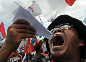 Seorang pengunjuk rasa menyindir pemerintah dengan menerbangkan pesawat kertas saat sekitar 10.000 pengunjuk rasa dari melakukan aksi menolak kenaikan harga bahan bakar minyak (BBM) di Istana Negara, Jakarta, Rabu (21/3). (Republika/Aditya Pradana Putra)