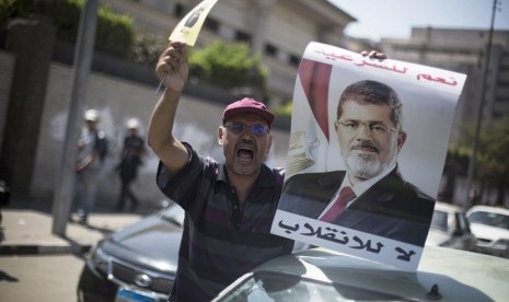  Seorang pengunjuk rasa pendukung Presiden Muhammad Mursi meneriakkan slogan  melawan militer Mesir dalam aksi unjuk rasa di dekat masjid Al-Nour di Kairo, Jumat (23/8).   (AP/Manu Brabo)