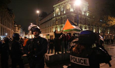 Seorang pengunjuk rasa (tengah) mengibarkan bendera Palestina saat demonstrasi mendukung warga Palestina di Place de la Republique di Paris, pada 19 Oktober 2023.