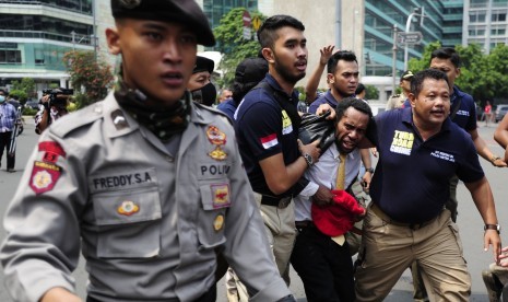 Seorang pengunjukrasa dari Aliansi Mahasiswa Papua diamankan polisi usai terlibat kericuhan ketika melakukan aksi di Kawasan Bundaran Hotel Indonesia, Jakarta, Selasa (1/12). 