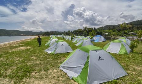 Seorang pengunjung berjalan di dekat tenda yang didirikan di area camping ground Kuta Beach Park The Mandalika, Kecamatan Pujut, Praya, Lombok Tengah, NTB, Rabu (9/3/2022). Guna memberikan alternatif tempat menginap bagi penonton MotoGP, telah tersedia camping ground kawasan Kuta Beach Park yang dilengkapi dengan tenda berbagai ukuran serta fasilitas pendukung lainnya seperti matras, kantong tidur dan tikar.