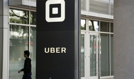 Seorang pengunjung berjalan di Kantor Uber di San Francisco. Uber mengumumkan rencana untuk go public