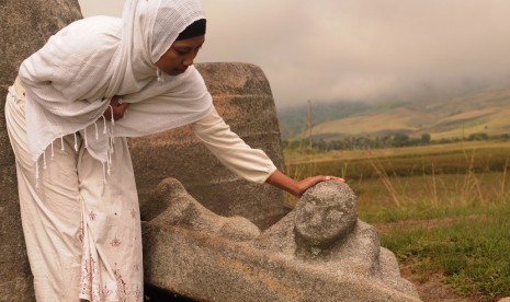 Seorang pengunjung memerhatikan salah satu ornamen penutup bejana raksasa (Kalampa) di situs megalith pokoke di Desa Besoa, Kec. Lore Tengah, Kab. Poso, Sulteng, Sabtu (4/6). Situs yang peninggalan zaman batu yang terdiri dari bejana raksasa dan patung bat