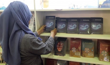 Seorang pengunjung memperhatikan buku 