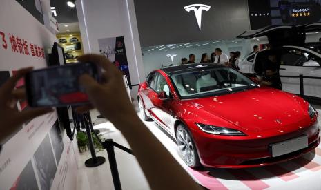 Seorang pengunjung mengambil gambar sedan Model 3 Tesla yang dipamerkan di Pameran Perdagangan Jasa Internasional China (CIFTIS) di Beijing, China, 2 September 2023. 