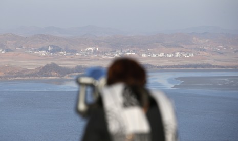 Seorang pengunjung menggunakan teropong untuk melihat wilayah Korea Utara dari observatorium unifikasi di Paju, utara Seoul, Korea Selatan, Kamis, 7 Januari, 2016. 