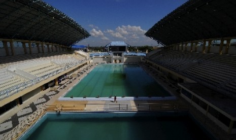 Seorang penjaga melintasi Stadion Renang Aquatic Center di Rumbai, Pekanbaru, Riau. Kolam tersebut merupakan veneu (arena) renang untuk PON XVIII Riau tahun 2012.