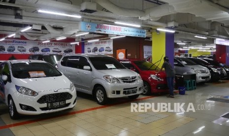 Seorang penjaga showroom mobil bekas di bilangan Kemayoran Jakarta, sedang memoles barang jajaran mobilnya agar terlihat bersih dan rapih, Selasa (3/10). 