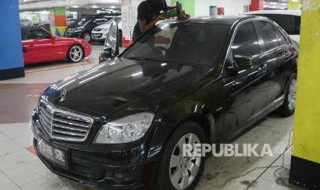 Seorang penjaga showroom mobil bekas di bilangan Kemayoran Jakarta, sedang memoles barang jajaran mobilnya agar terlihat bersih dan rapih, Selasa (3/10). 