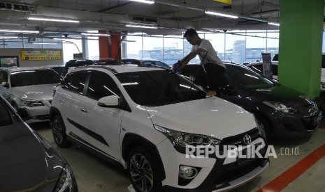 Seorang penjaga showroom mobil bekas di bilangan Kemayoran Jakarta, sedang memoles barang jajaran mobilnya agar terlihat bersih dan rapih, Selasa (3/10). 