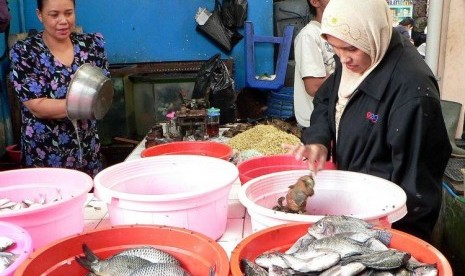 Seorang penjual ikan (kiri) melayani seorang pembeli ikan di pasar Temanggung, Jateng,