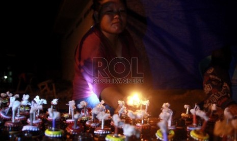 Seorang penjual lampu minyak daur ulang di Kota Gorontalo, sedang mencoba lampu minyak yang akan di jual, jumat (2/8). 