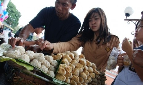  Seorang penjual penjual pempek tengah melayani pembeli (ilustrasi).