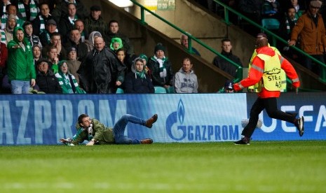 Seorang penonton (kiri) didekati oleh petugas keamanan (kanan) ketika laga antara Celtic dan Paris Saint-Germain di Celtic Park, Glasgow, Skotlandia, 12 September 2017.