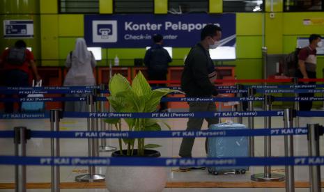 Seorang penumpang berjalan menuju pintu keberangkatan kereta api di Stasiun Gambir, Jakarta.