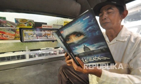 Seorang penumpang membaca buku dalam angkot Ungaran- Karangjati, Senin (19/2). Salah satu angkot di ibu kota Kabupaten Semarang menyediakan perpustakaan mini agar penumpang tidak jenuh dan gemar membaca. 