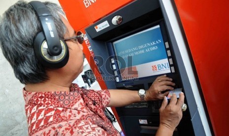 Seorang penyandang disabilitas mencoba bertransaksi di mesin ATM Bank BNI yang dilengkapi fasilitas bagi penyandang disabilitas di Gedung Kementerian Sosial, Jakarta, Selasa (1/12).(Republika/Agung Supriyanto)