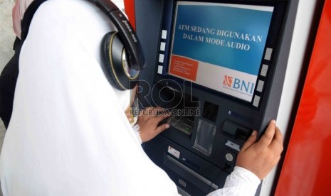 Seorang penyandang disabilitas mencoba bertransaksi di mesin ATM Bank BNI yang dilengkapi fasilitas bagi penyandang disabilitas di Gedung Kementerian Sosial, Jakarta, Selasa (1/12).